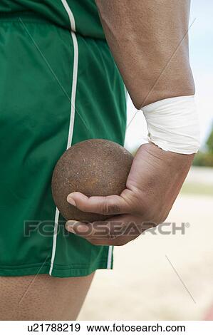 Male shot putter holding shot, close-up view View Large Photo Image Stock Photo - Male shot putter holding shot, close-up view. Fotosearch