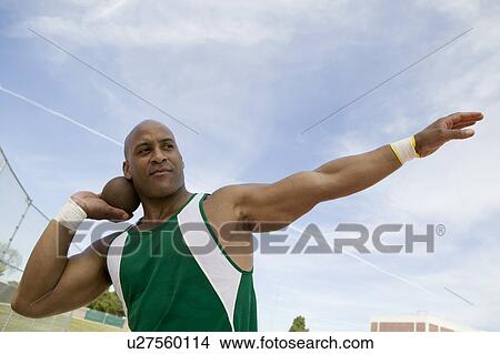 Picture - Male shot putter holding shot. Fotosearch