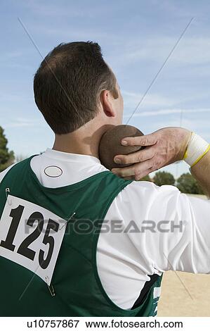 Stock Photo - Male shot putter holding shot. Fotosearch
