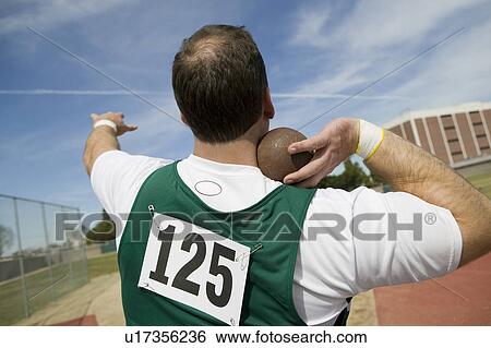 Stock Photograph - Male shot putter holding shot. Fotosearch