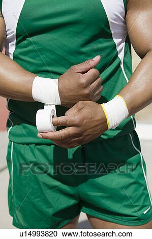 Male shot putter wrapping wrist tape, mid section View Large Photo Image Stock Image - Male shot putter wrapping wrist tape, mid section. Fotosearch