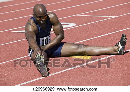 Male sprinter stretching on track View Large Photo Image Stock Photo - Male sprinter stretching on track. Fotosearch