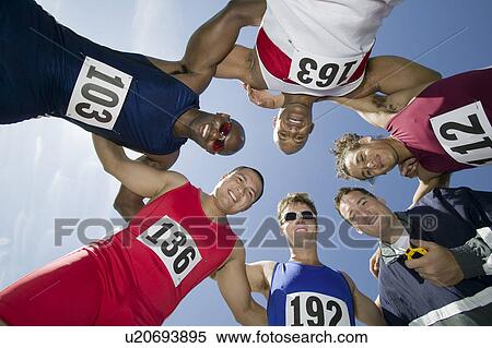 Stock Photography - Male sprinters in huddle, view from below. Fotosearch