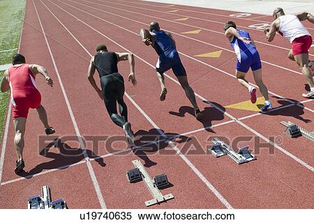 Stock Photography - Male sprinters leaving starting blocks. Fotosearch