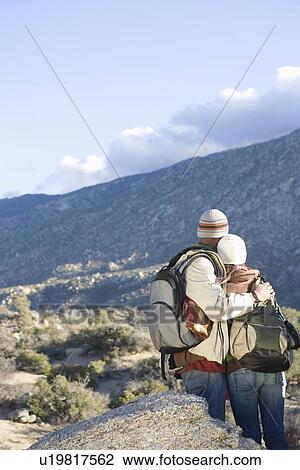 Man and woman stand looking at mountain view View Large Photo Image Stock Image - Man and woman stand looking at mountain view. Fotosearch