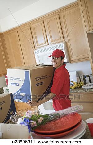Man carrying a box in kitchen View Large Photo Image Stock Image - Man carrying a box in kitchen. Fotosearch
