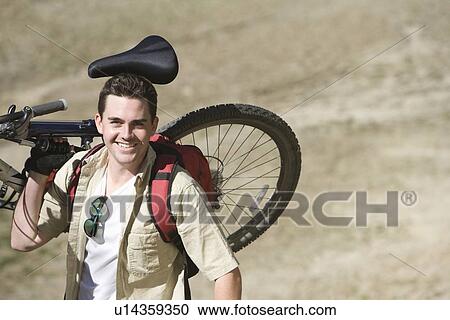 Man carrying mountain bike View Large Photo Image Stock Image - Man carrying mountain bike. Fotosearch