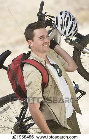 Man carrying mountain bike View Large Photo Image Stock Photograph - Man carrying mountain bike. Fotosearch