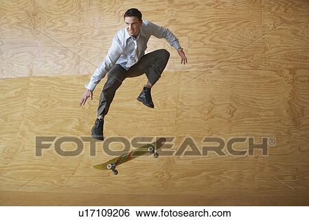 Man crouching, jumping from skateboard, mid-air, in front of interior wall View Large Photo Image Stock Photograph - Man crouching, jumping from skateboard, mid-air, in front of interior wall. Fotosearch