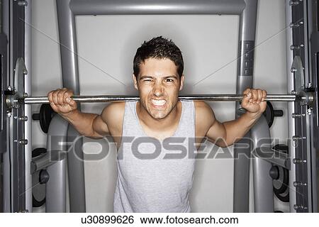 Man Grimacing while Lifting Weights on weight machine, portrait View Large Photo Image Stock Photograph - Man Grimacing while Lifting Weights on weight machine, portrait. Fotosearch