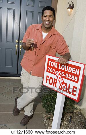 Stock Image - Man holding keys to his new home. Fotosearch