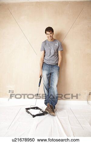 Man holding paint roller in paint tray, in unrenovated room, portrait View Large Photo Image Stock Image - Man holding paint roller in paint tray, in unrenovated room, portrait. Fotosearch