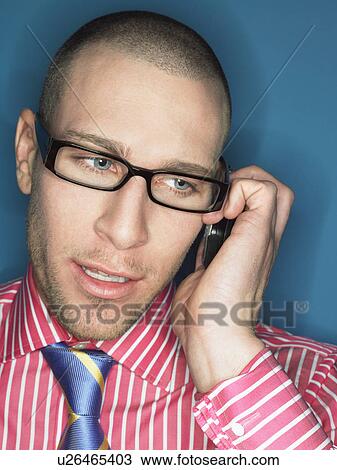 Stock Image - Man in glasses on cell phone, head and shoulders. Fotosearch