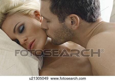 Man kissing woman asleep in bed, close-up View Large Photo Image Stock Photo - Man kissing woman asleep in bed, close-up. Fotosearch