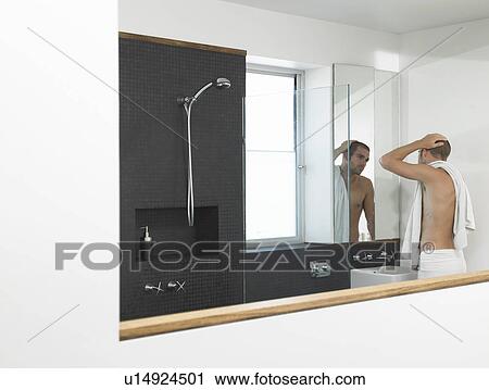 Man looking at himself in bathroom mirror, half-length View Large Photo Image Stock Image - Man looking at himself in bathroom mirror, half-length. Fotosearch