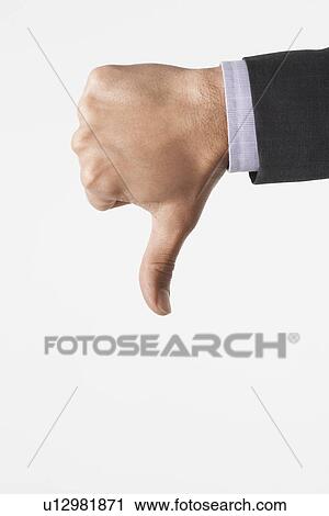 Stock Image - Man making thumbs-down sign against white background, close-up of hand. Fotosearch