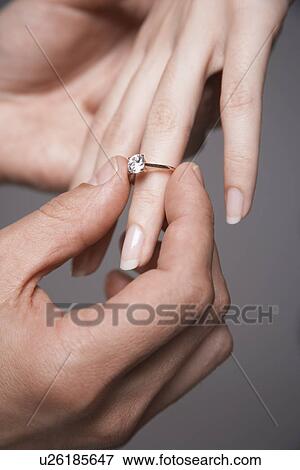 Man placing engagement ring on woman's finger, close-up of hands View Large Photo Image Stock Photo - Man placing engagement ring on woman's finger, close-up of hands. Fotosearch