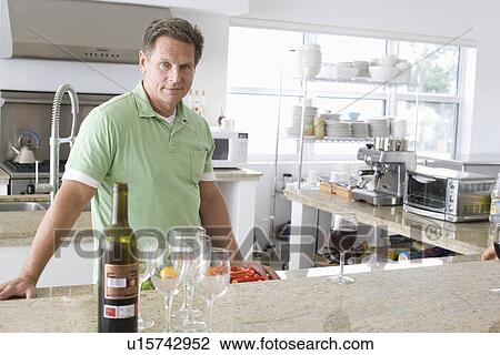 Stock Image - Man preparing food in kitchen. Fotosearch
