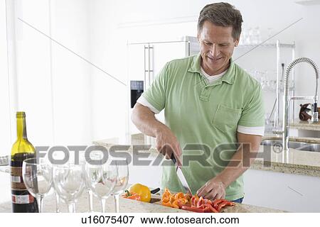 Man preparing food in kitchen View Large Photo Image Stock Photo - Man preparing food in kitchen. Fotosearch