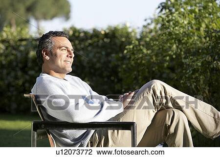Stock Image - Man Relaxing in Garden. Fotosearch