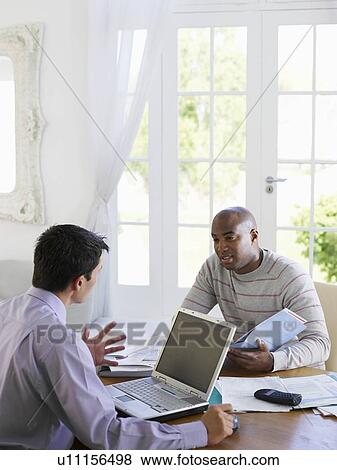 Man sitting at dinning table with financial advisor View Large Photo Image Stock Photo - Man sitting at dinning table with financial advisor. Fotosearch