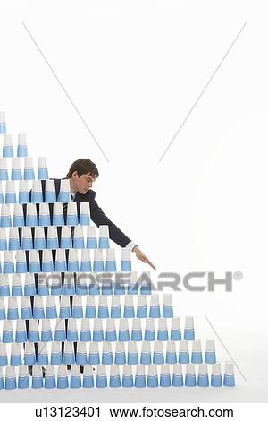 Man stacking plastic cups into a pyramid against white background View Large Photo Image Stock Image - Man stacking plastic cups into a pyramid against white background. Fotosearch