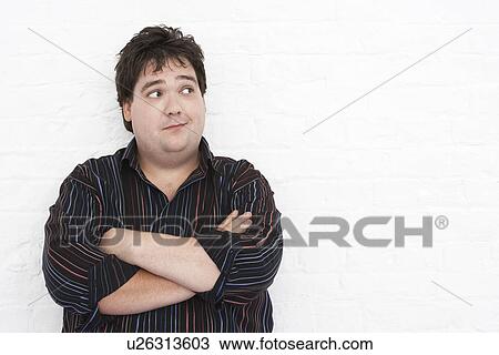 Man standing against wall with Arms Crossed looking to left, portrait View Large Photo Image Stock Image - Man standing against wall with Arms Crossed looking to left, portrait. Fotosearch
