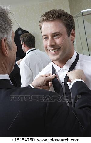 Man tying groom's bow tie View Large Photo Image Stock Image - Man tying groom's bow tie. Fotosearch
