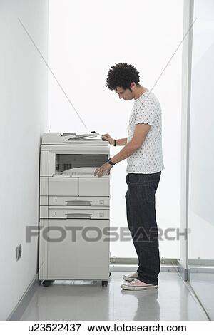 Man using copy machine in hallway View Large Photo Image Stock Photo - Man using copy machine in hallway. Fotosearch
