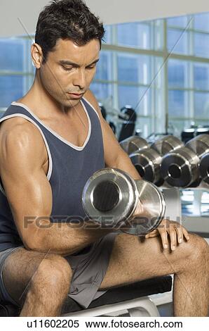 Man using dumbbell in gymnasium View Large Photo Image Stock Photography - Man using dumbbell in gymnasium. Fotosearch