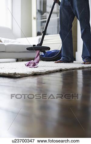 Man vacuuming tie from rug, low section View Large Photo Image Stock Photo - Man vacuuming tie from rug, low section. Fotosearch