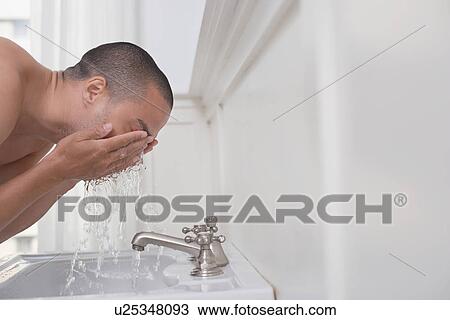 Man washing face in bathroom sink View Large Photo Image Stock Image - Man washing face in bathroom sink. Fotosearch