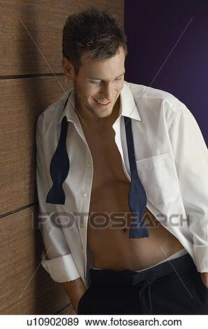 Man wearing tuxedo, looking down, indoors View Large Photo Image Stock Photo - Man wearing tuxedo, looking down, indoors. Fotosearch