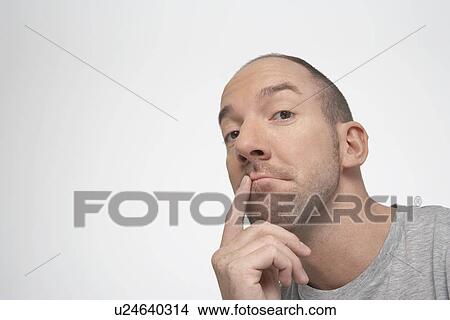 Picture - Man with finger on lips, thinking. Fotosearch