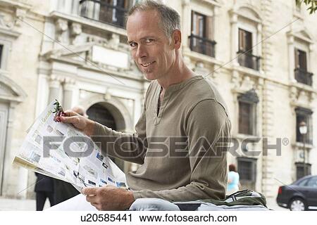 Stock Image - Man with Guidebook in Street. Fotosearch