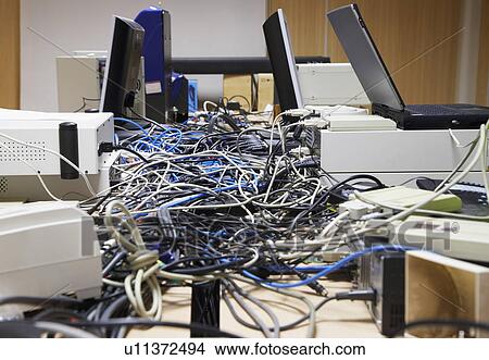 Mess of wires connecting computers and printers in office View Large Photo Image Picture - Mess of wires connecting computers and printers in office. Fotosearch