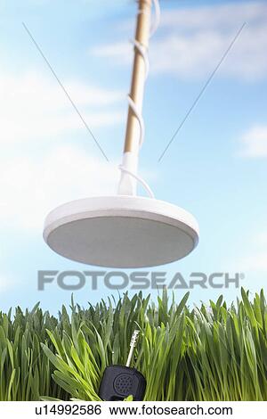Stock Photograph - Metal detector finding key in grass. Fotosearch