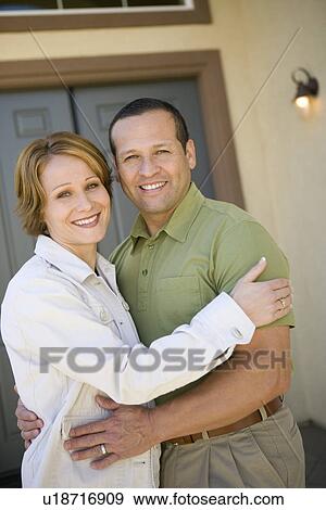 Mid-adult couple in front of house View Large Photo Image Stock Photo - Mid-adult couple in front of house. Fotosearch