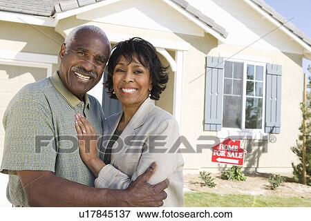 Mid-adult couple in front of new house, portrait View Large Photo Image Stock Photo - Mid-adult couple in front of new house, portrait. Fotosearch