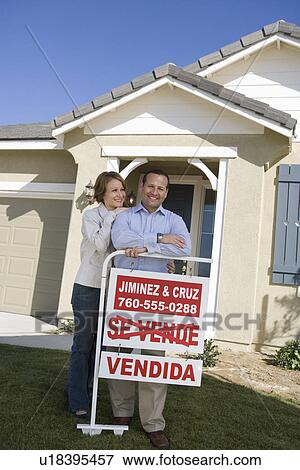Stock Photo - Mid-adult couple in front of new house, portrait. Fotosearch
