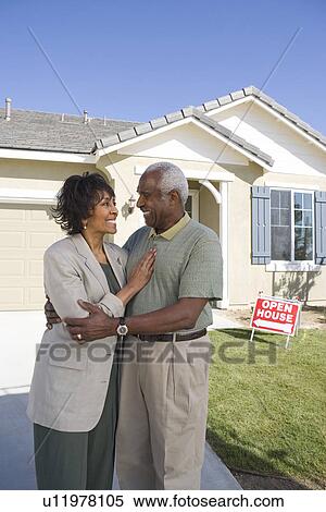Stock Photography - Mid-adult couple in front of new house, portrait. Fotosearch