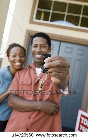 Mid adult couple in front of their new home View Large Photo Image Stock Image - Mid adult couple in front of their new home. Fotosearch