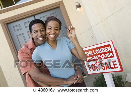 Mid adult couple in front of their new home View Large Photo Image Stock Photo - Mid adult couple in front of their new home. Fotosearch