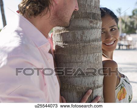 Stock Image - Mid-adult couple on beach. Fotosearch