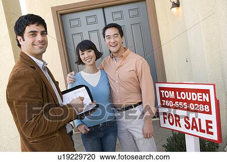Mid adult couple with estate agent n front of their new home View Large Photo Image Stock Image - Mid adult couple with estate agent n front of their new home. Fotosearch