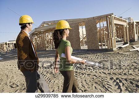 Mid adult man and young woman in construction site View Large Photo Image Stock Photography - Mid adult man and young woman in construction site. Fotosearch