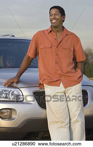 Mid adult man in front of car, smiling View Large Photo Image Stock Image - Mid adult man in front of car, smiling. Fotosearch