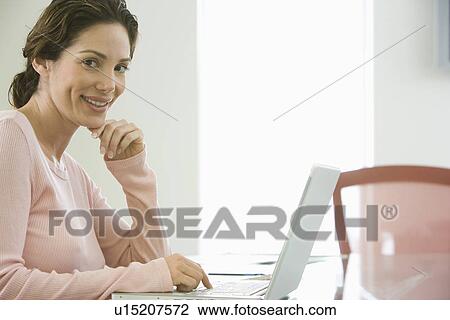 Mid-adult office worker with laptop View Large Photo Image Stock Image - Mid-adult office worker with laptop. Fotosearch