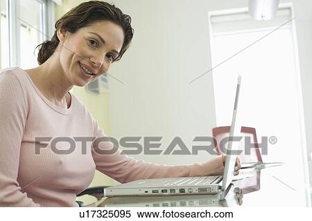 Mid-adult office worker with laptop View Large Photo Image Stock Photography - Mid-adult office worker with laptop. Fotosearch