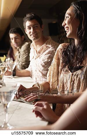 Mid-adult People standing at Bar with cocktail glasses, socializing View Large Photo Image Stock Photo - Mid-adult People standing at Bar with cocktail glasses, socializing. Fotosearch
